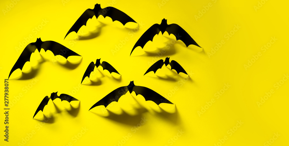 Minimalistic Paper bat pattern with falling shadow on yellow background. Halloween decorations banner. Halloween concept. Flat lay, top view, copy space. Minimalistic Paper bat pattern with falling shadow on yellow background. Halloween decorations banner. Halloween concept. Flat lay, top view, copy space.