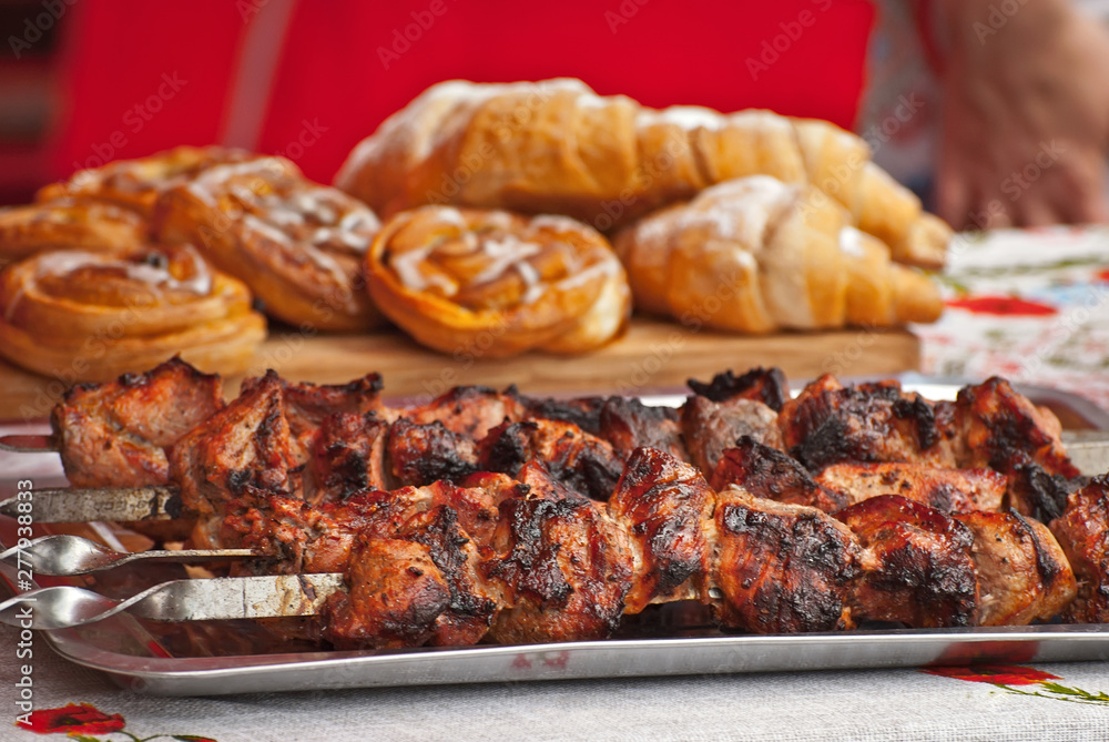 Barbecue fries in the coals. Meat and beef at the field kitchen festival. Fried meat on a green tray on the table. Barbecue fries in the coals. Meat and beef at the field kitchen festival. Fried meat on a green tray on the table.