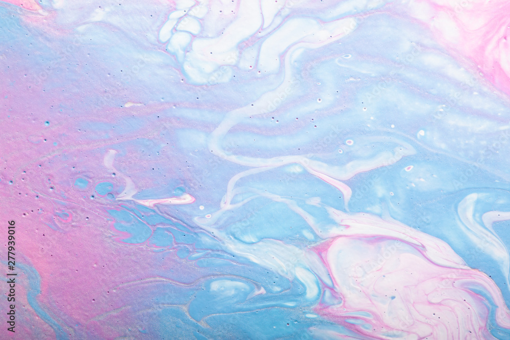 Abstract handmade composition made in the technique of fluid art. Bright art project in trendy pastel shades of pink and blue with white and silver lines and droplets interspersing.