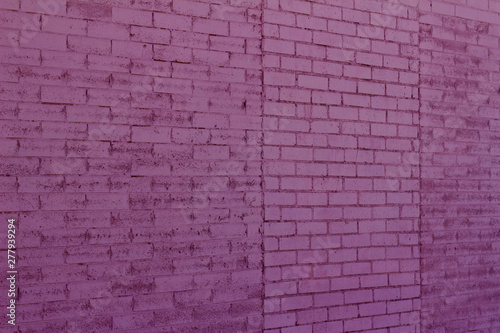 Old weathered brick wall texture background with bricks painted an attractive purple color  angle view 