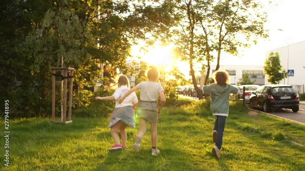 Classmates teenagers play in the park during school recess. Sun glare during sunset Classmates teenagers play in the park during school recess. Sun glare during sunset