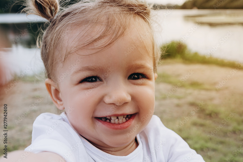 a portrait of a little smiling baby girl who stretches her hands to someone to hug and kiss, the emotion of happiness, joy, funny childhood a portrait of a little smiling baby girl who stretches her hands to someone to hug and kiss, the emotion of happiness, joy, funny childhood