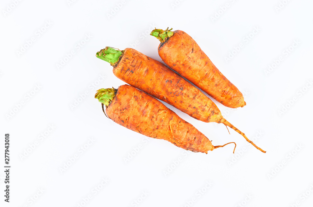 Three fresh carrot isolated on white background. The view from the top. Organic food background. Three fresh carrot isolated on white background. The view from the top. Organic food background.