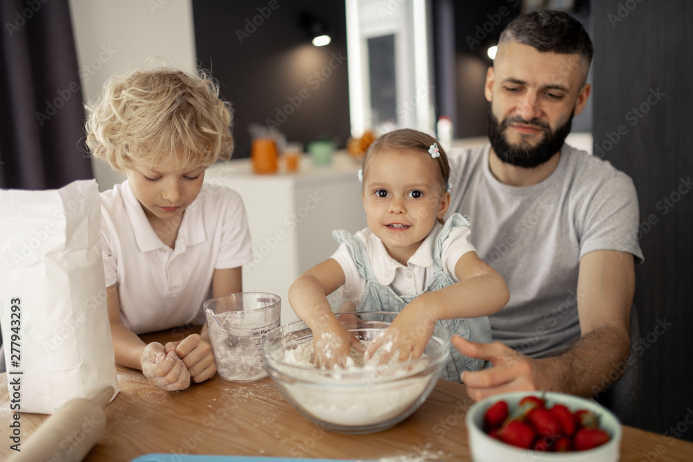 Positive cute girl putting her hands in flour Positive cute girl putting her hands in flour