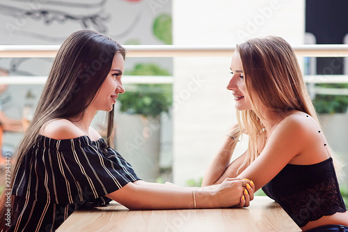 happy girlfriends in love and joy spend time together in a cafe
