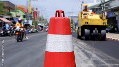 Focus on traffic cone with blurred background of paving asphalt in road construction site and transport zone demarcation on the street in the city