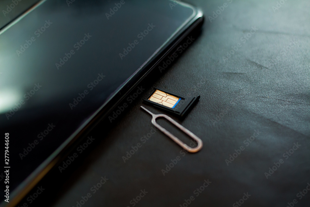 The phone is changing,nano sim card in the store and SIM card adapter to change the size to a micro sim card and the usual SIM card size on a black cushion background.