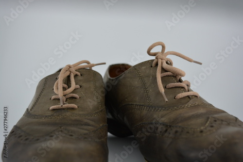 Women's unusual gray brown shoes, shoes from genuine leather in the English style. Aristocratic and antique shoes with worn leather and special colors are located on a white background.