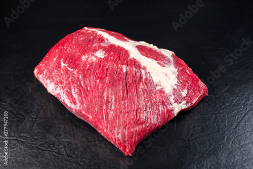 Raw wagyu bavette steak as closeup on black background with copy space