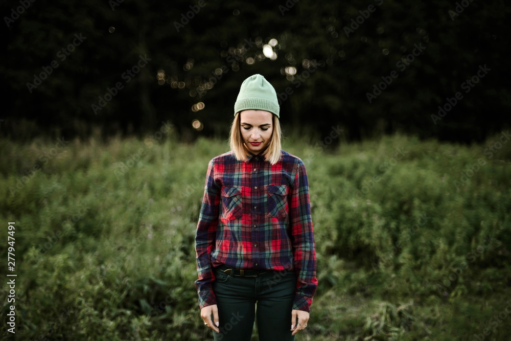 Young beautiful hipster woman standing on field in the countryside Young beautiful hipster woman standing on field in the countryside