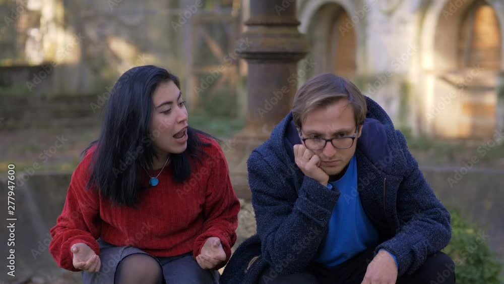 Angry young Woman Talking To Calm absent in mind Young Man in the park Angry young Woman Talking To Calm absent in mind Young Man in the park