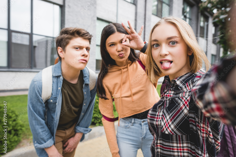 positive teenagers taking selfie and showing ok gesture outside positive teenagers taking selfie and showing ok gesture outside