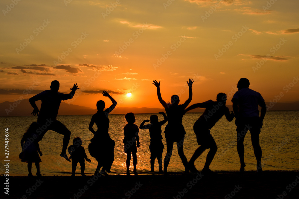 silhouette of friends jumping on beach during sunset time