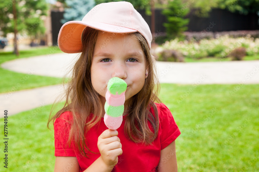 Cute Toddler Girl Eating Ice-Cream outdoors. Child on a walk in the park in summer day. Lifestyle, happy summertime, family vacations, summer outdoor portrait Cute Toddler Girl Eating Ice-Cream outdoors. Child on a walk in the park in summer day. Lifestyle, happy summertime, family vacations, summer outdoor portrait