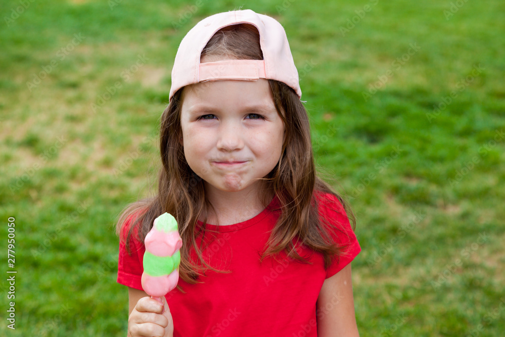 Cute Toddler Girl Eating Ice-Cream outdoors. Child on a walk in the park in summer day. Lifestyle, happy summertime, family vacations, summer outdoor portrait Cute Toddler Girl Eating Ice-Cream outdoors. Child on a walk in the park in summer day. Lifestyle, happy summertime, family vacations, summer outdoor portrait