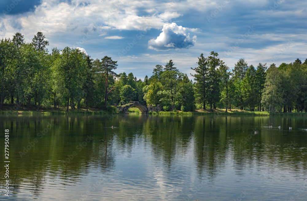 Summer panoramic landscape on the lake with old bridge. Gatchina. Russia