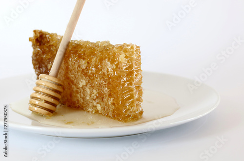  Favo con miele su un piatto bianco isolato su sfondo bianco