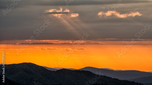 Fototapeta Naklejka Na Ścianę i Meble -  A wonderful sunset in the mountains. Orange sky and dark silhouettes of mountains. Carpathian Mountains landscape. Bieszczady. Poland