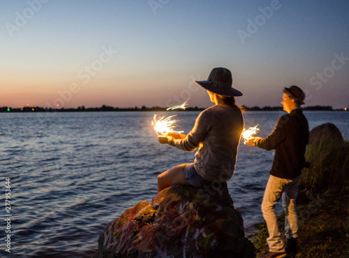 Friends with sparklers on road trip celebrating the summer seaso photo