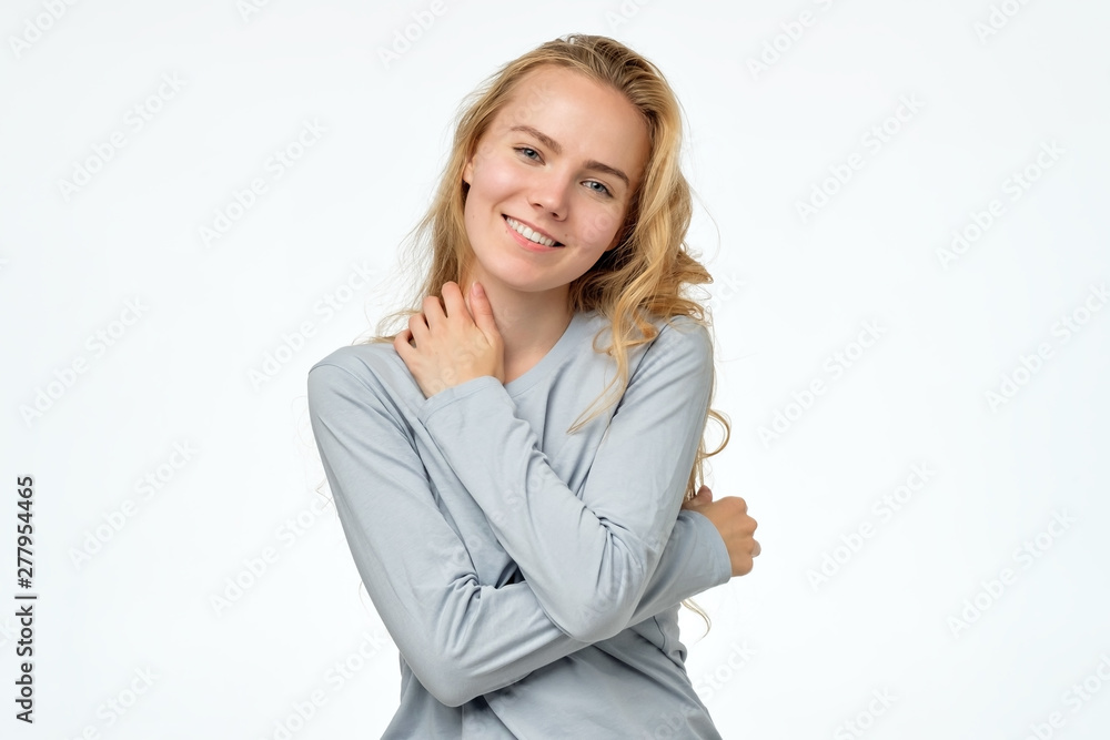 Happy blonde girl in blue pulover smiling looking at camera. White background. Positive facial emotion. Happy blonde girl in blue pulover smiling looking at camera. White background. Positive facial emotion.