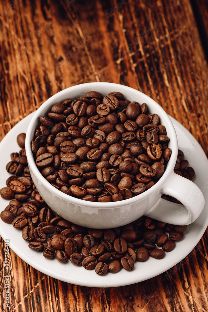 Cup full of roasted coffee beans Cup full of roasted coffee beans