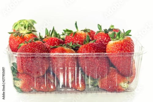 Package of strawberries on a white background, close up, isolated.
