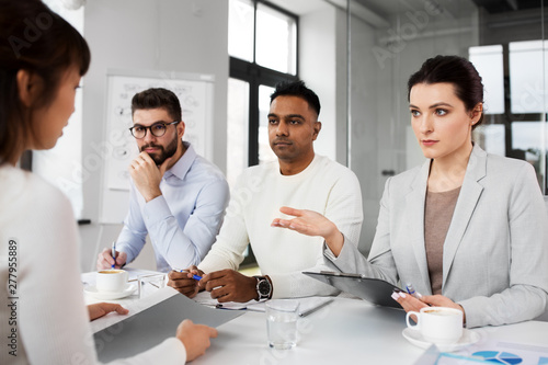 new job, hiring and employment concept - international team of recruiters having interview with female employee at office