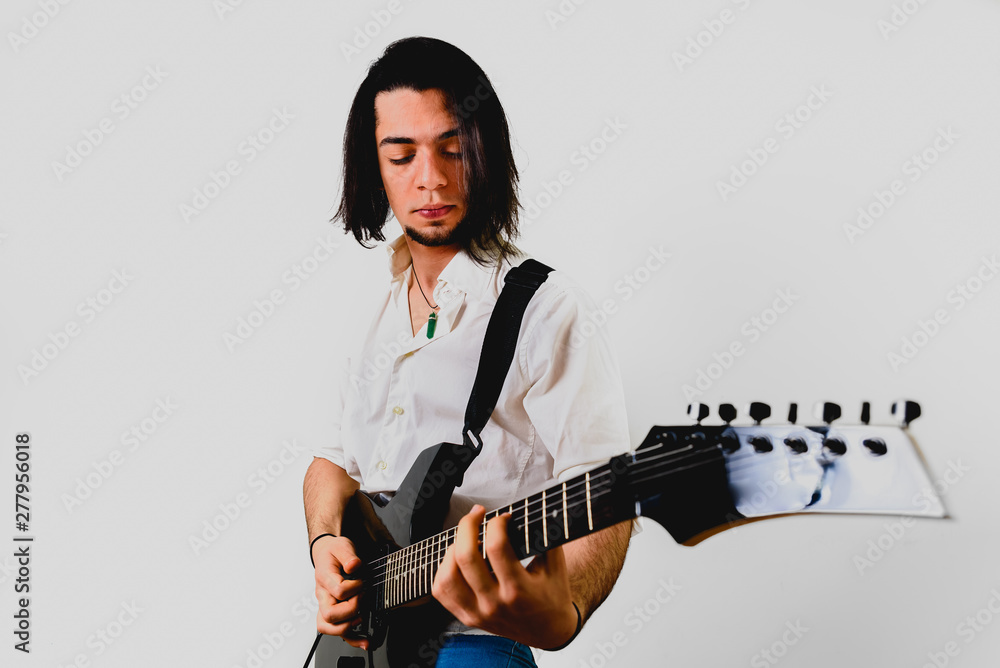 Guitarist posing with his electric guitar, white background.