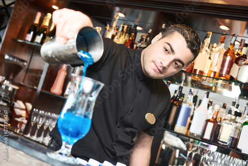 Professional bartender making cocktail in bar
