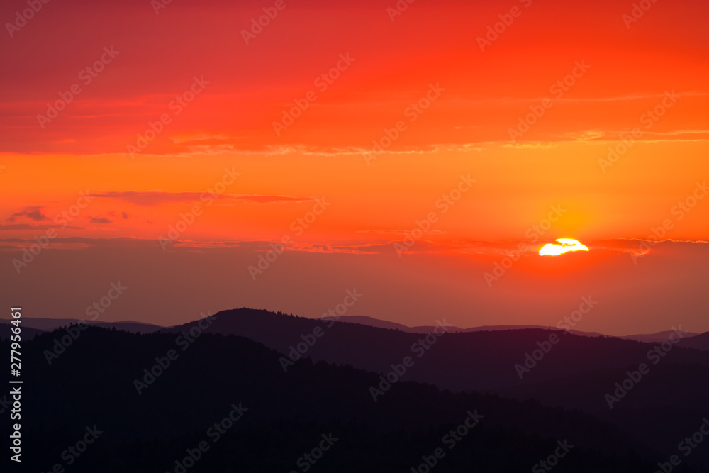 A wonderful sunset in the mountains. Orange sky and dark silhouettes of mountains. Carpathian Mountains landscape. Bieszczady. Poland