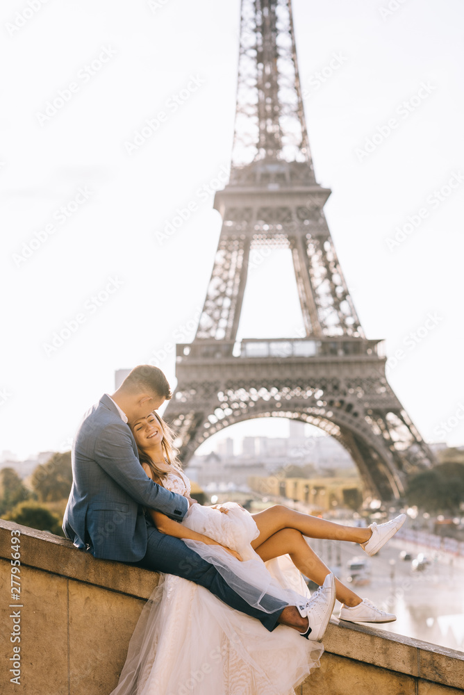 Happy romantic married couple hugging near the Eiffel tower in Paris