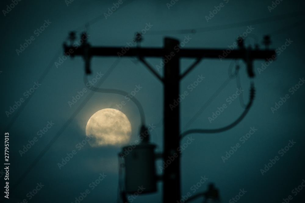 A full moon framed in a power line transformer A full moon framed in a power line transformer