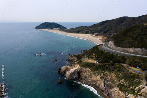 Aerial view of winding road and beach by ocean photo