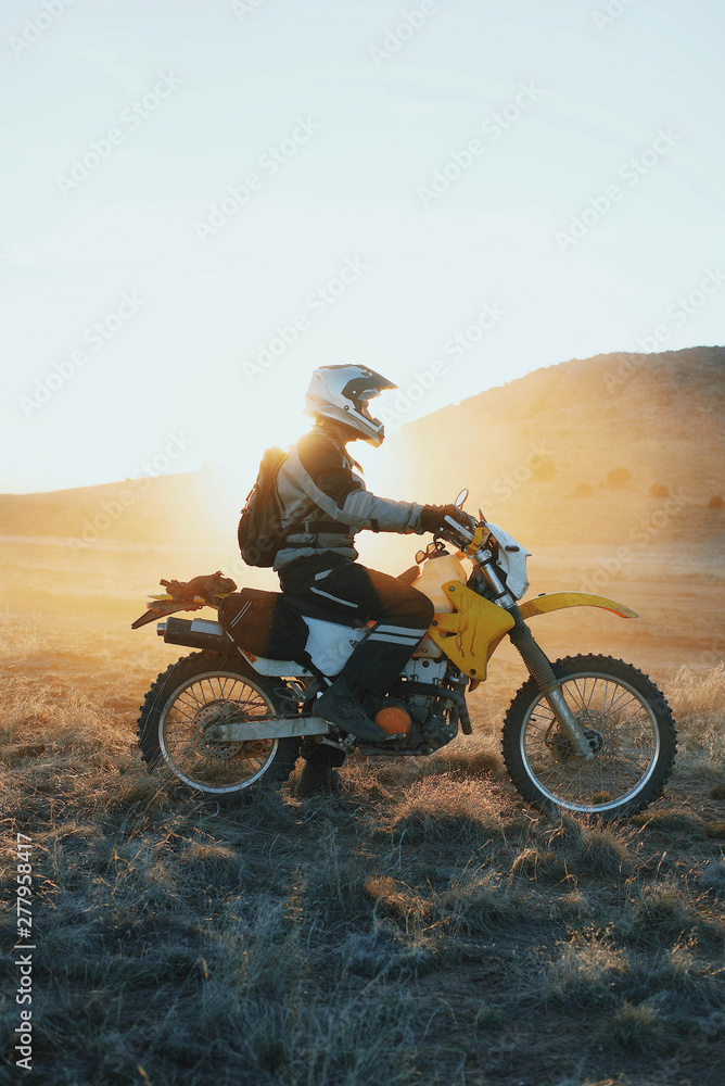 Side view of man sitting on motorbike in desert Side view of man sitting on motorbike in desert