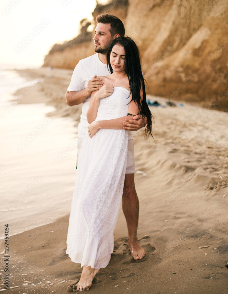 Beach couple walking on romantic travel honeymoon vacation summer holidays romance. Young happy lovers. Beach couple walking on romantic travel honeymoon vacation summer holidays romance. Young happy lovers.