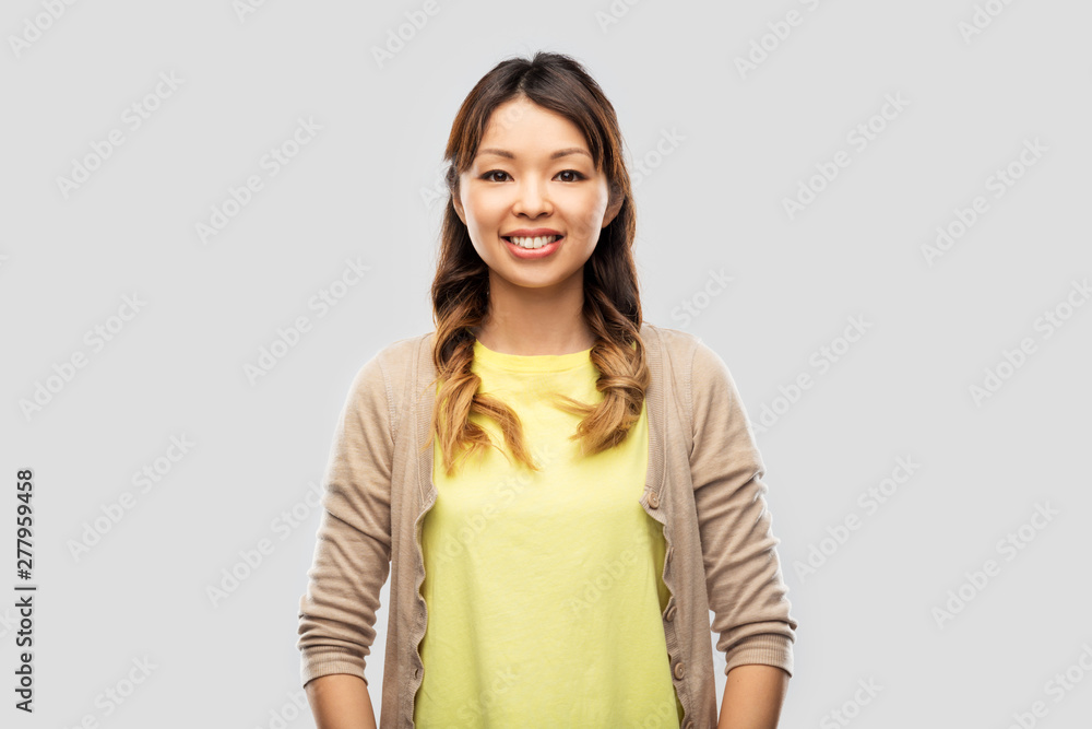 people, ethnicity and portrait concept - happy asian young woman over grey background people, ethnicity and portrait concept - happy asian young woman over grey background