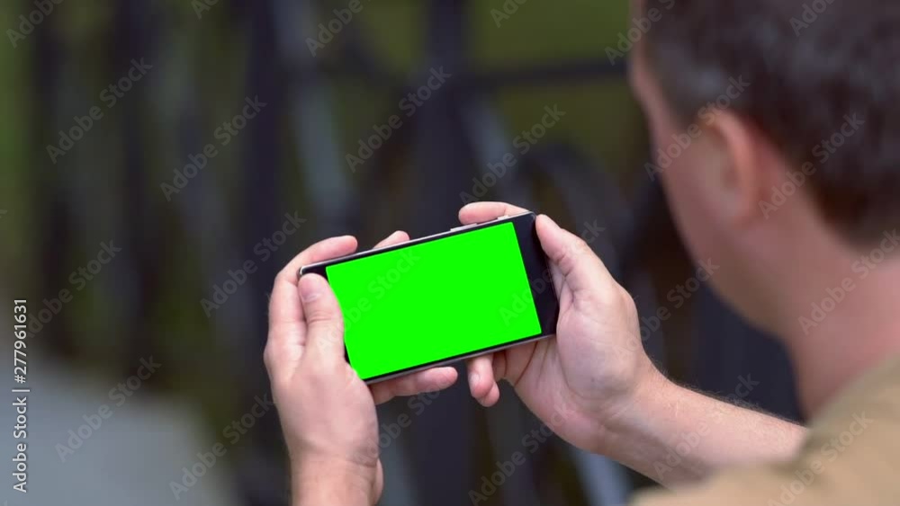 Man engrossed in reading on a mobile phone
