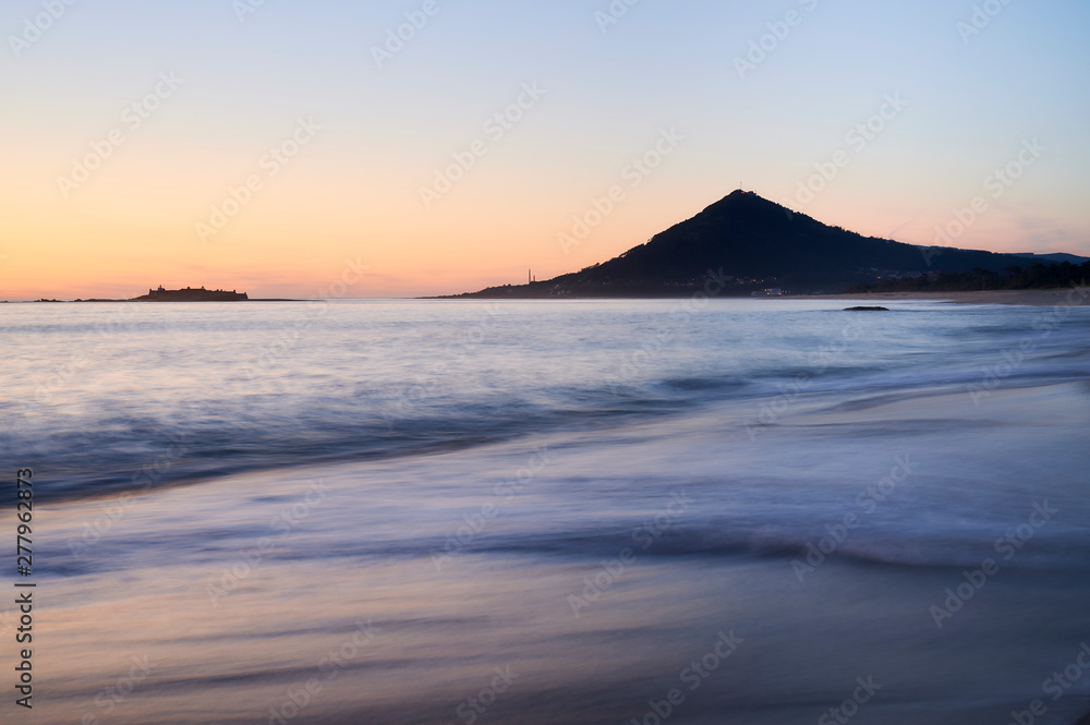 Sunset at the Moledo beach, with a mountain on backgroud