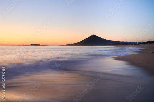 Sunset at the Moledo beach, with a mountain on backgroud © Aldrin