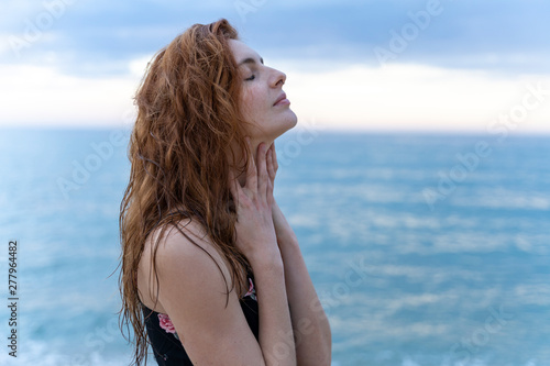 Young man with eyes closed in front of the sea