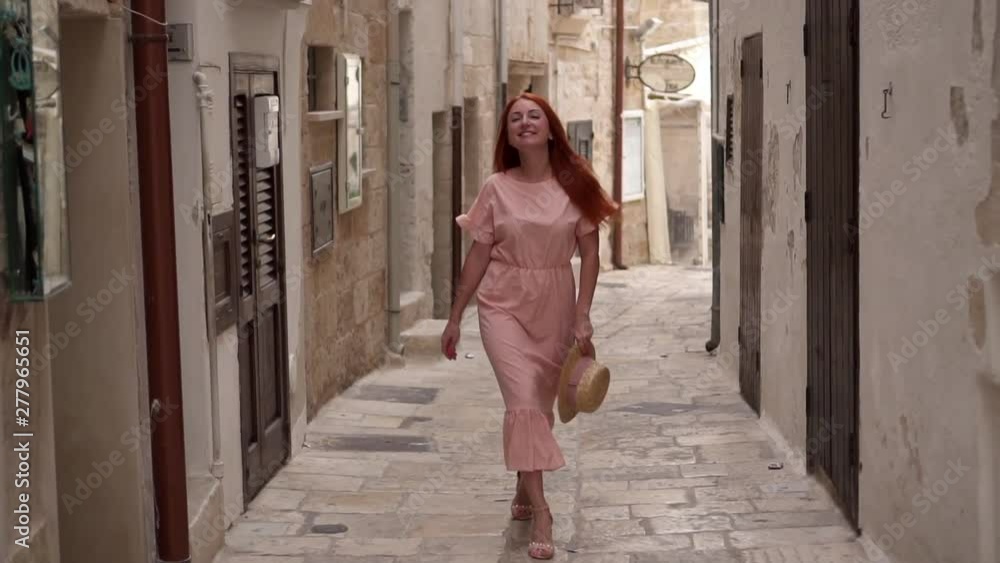Happy young woman tourist walking through streets of old European city, slow motion Happy young woman tourist walking through streets of old European city, slow motion