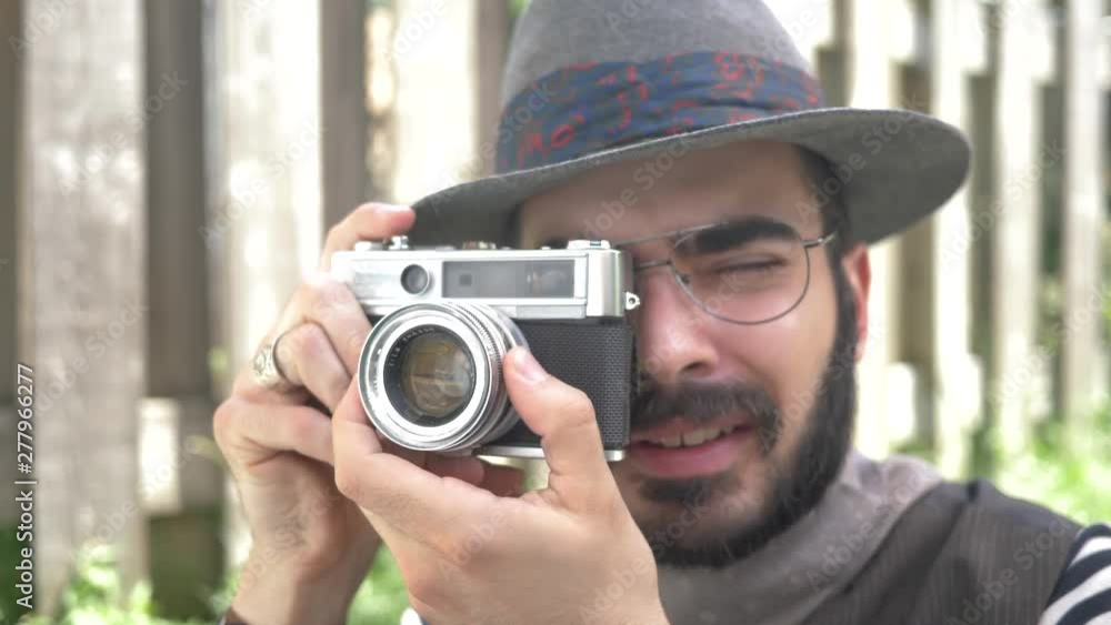 Millennial hipster using an old 35mm film camera outdoors Millennial hipster using an old 35mm film camera outdoors
