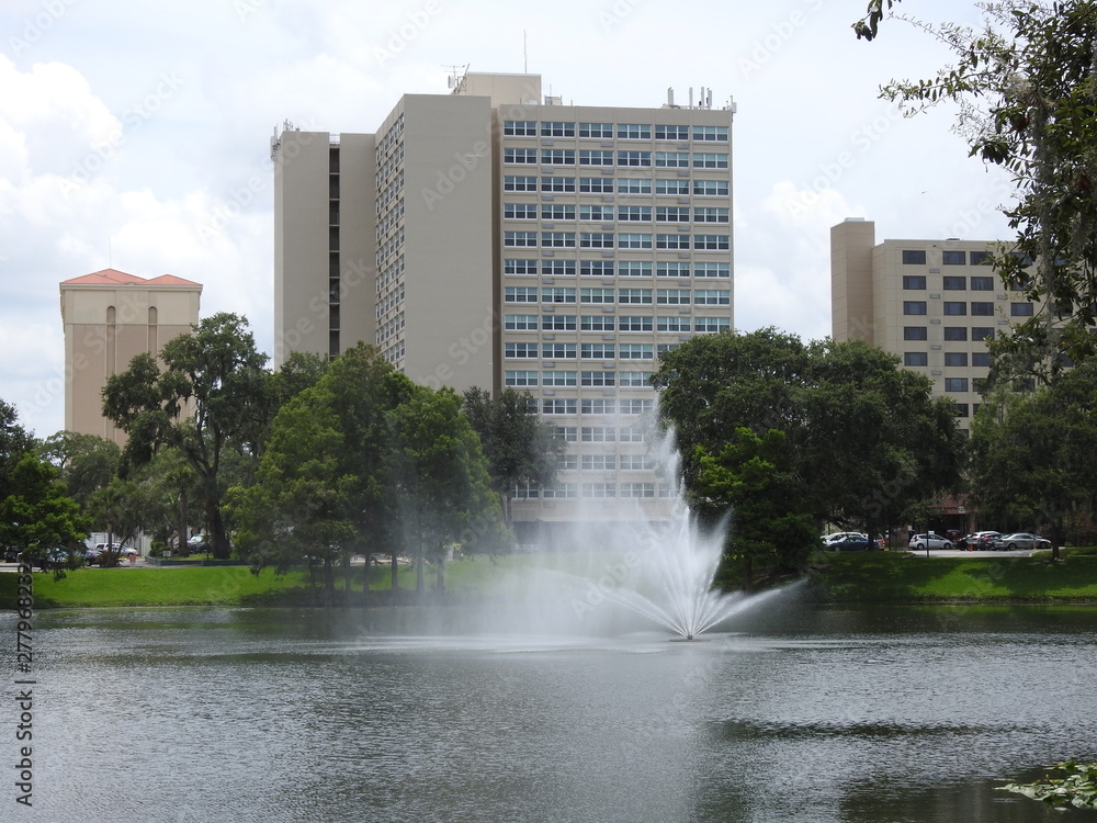 A Fountain in a Lake with buildings in the background in Orlando in Florida!