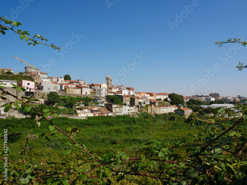Wide angle cityscape view of Porto, Portugal, with Lapa Church visible in distance