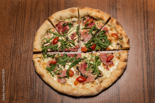 top view of one half and four pieces of pizza with arugula