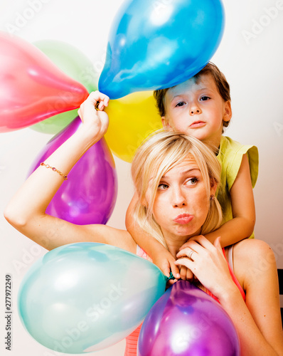 pretty real family with color balloons on white background, blond woman with little boy at birthday party bright smiling mother