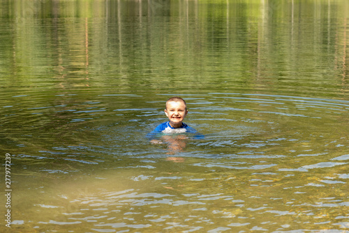 boy swimming in lake 