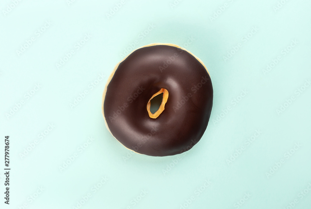 A chocolate tasty doughnut on turquoise background. A chocolate tasty doughnut on turquoise background.