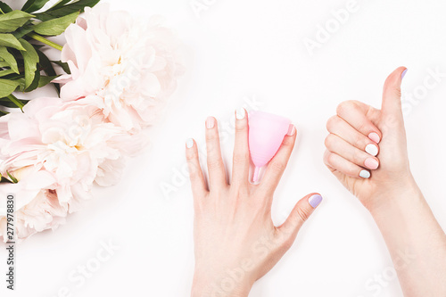 Creative shot of menstrual cup in woman hands. Feminine and lifestyle background.