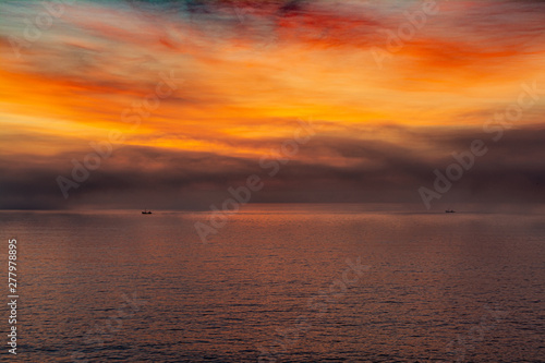 amanecer cálido sobre el mar con grandes nubes coloridas